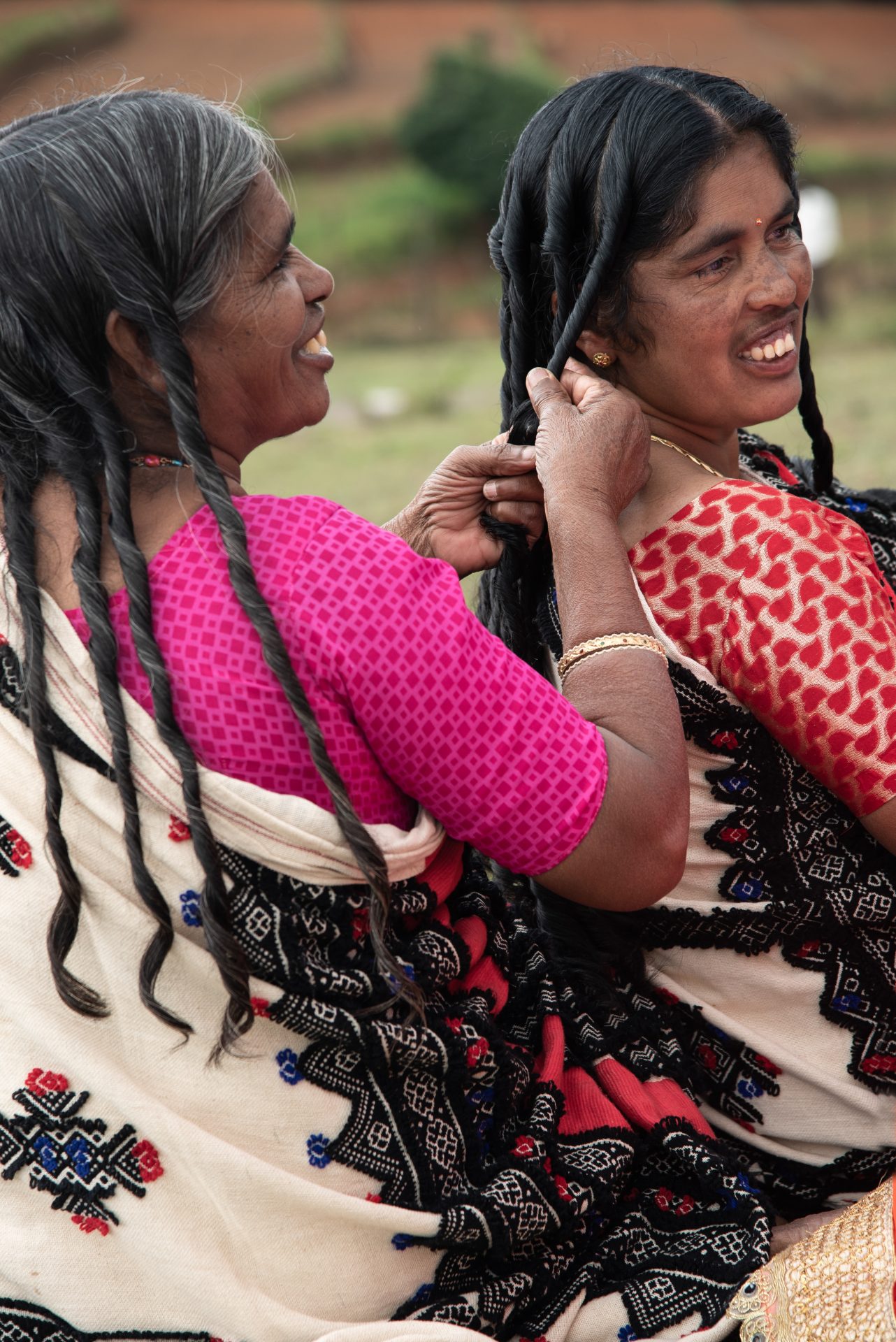 An image of two women: one is doing the other's hair.